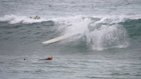 Gran-Canaria-Spain---February-9-2023:-Surfers-try-to-ride-waves-at-Las-Canteras-beach-in-Las-Palmas-de-Gran-Canaria,-Spain