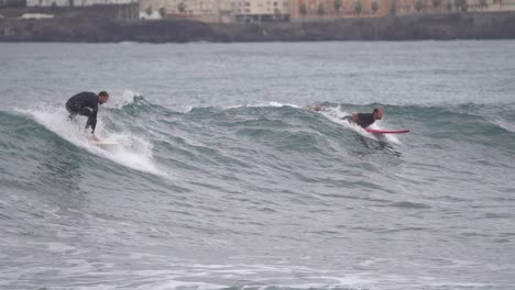 Gran-Canaria-Spain---February-9-2023:-Surfers-try-to-ride-waves-at-Las-Canteras-beach-in-Las-Palmas-de-Gran-Canaria,-Spain