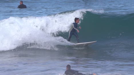 Gran-Canaria-Spain---February-9-2023:-Surfers-try-to-ride-waves-at-Las-Canteras-beach-in-Las-Palmas-de-Gran-Canaria,-Spain