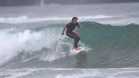 Gran-Canaria-Spain---February-9-2023:-Surfers-try-to-ride-waves-at-Las-Canteras-beach-in-Las-Palmas-de-Gran-Canaria,-Spain