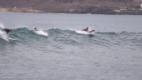 Gran-Canaria-Spain---February-9-2023:-Surfers-try-to-ride-waves-at-Las-Canteras-beach-in-Las-Palmas-de-Gran-Canaria,-Spain