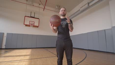 Tiefwinkel-Weitwinkelaufnahme-Eines-Mannes,-Der-Spielerisch-Einen-Basketball-Hält