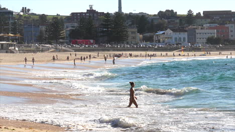 Two-swimmers-enter-the-ocean-at-Bondi-Beach,-Sydney-Australia