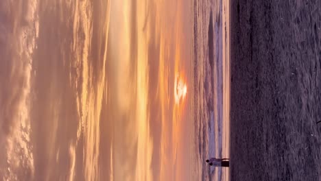 Playa-Romántica-Puesta-De-Sol-Naranja-Con-Una-Pareja-Joven-Abrazándose