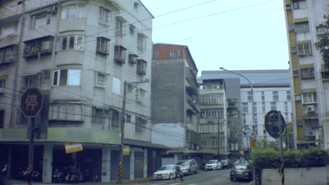 Hand-Hält-Stille-Ansicht-Des-Ghettos.-Altes-Schmutziges-Asiatisches-Wohnhaus-Mit-Alten,-Einfachen-Strommasten-Und-Völlig-Entblößten-Fenstern.-Balkon-In-Der-Ecke,-Ein-Schild-Auf-Chinesisch-„zu-Vermieten“-Und-Fußgänger,-Die-Spazieren-Gehen