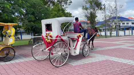 Los-Turistas-Disfrutan-Del-Paseo-En-Carruaje-De-Caballos-Cerca-De-Los-Sitios-Históricos-De-Malaca-En-Malasia