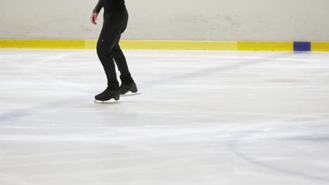 Joven-Patinador-Sobre-Hielo-Patinando-Suavemente-En-Cámara-Lenta-Sobre-Hielo-En-Una-Pista