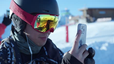 Nahaufnahme-Eines-Jungen-Menschen,-Der-An-Einem-Sonnigen-Tag-Mit-Einem-Handy-Auf-Einer-Skipiste-Filmt