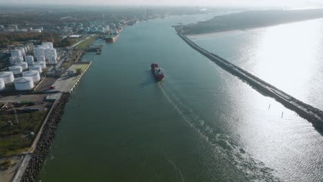 Vista-Aérea-De-Un-Carguero-Rojo-Navegando-En-La-Zona-Del-Puerto,-También-Conocida-Como-La-Laguna-Curoniana