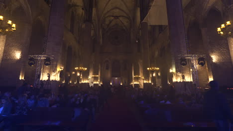 People-entering-Barcelona-Cathedral-for-concert,-boom-up-view