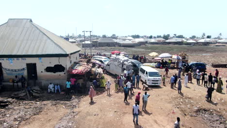 Ferry-crossing-and-outdoor-market-along-the-Benue-River-at-Ibi-Town,-Nigeria---aerial-flyover