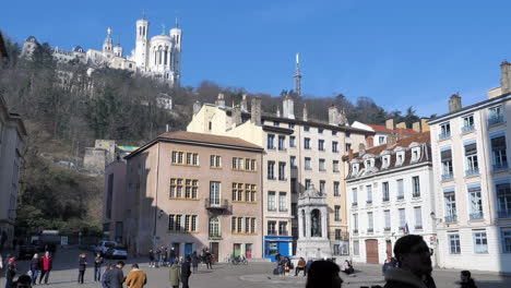 Menschen,-Die-Durch-Die-Straßen-Der-Stadt-Lyon-Flanieren,-Mit-Der-Basilika-Notre-Dame-De-Fourvière-Im-Hintergrund