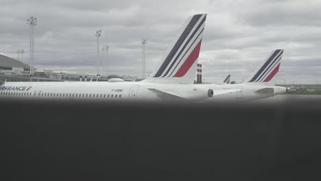 Air-France-jets-parked-at-gates-at-airport,-Elevator-descending-view-shot