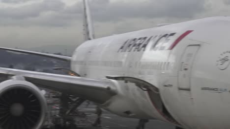 Jet-De-Air-France-777-Estacionado-En-La-Puerta-Del-Aeropuerto-Mientras-Carga-Carga,-Tiro-Pan-Izquierdo