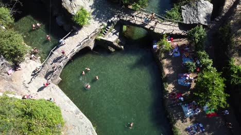 Topdown-view-of-River-Beach-of-Foz-D'Égua,-tourists-Swim-and-sunbathe-in-the-Rocks,-Portugal