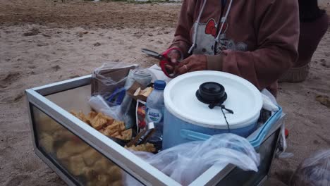 Balinese-Old-Woman-Sells-Lumpia-Street-Fried-Food-in-Bali,-Indonesia-Sanur-Beach-Tofu-and-Spring-Rolls-with-Sweet-Sauce-and-Green-Chilli