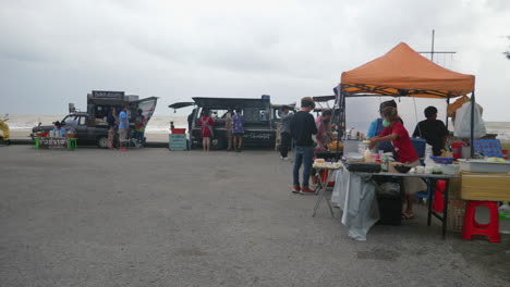 People-buying-street-food-from-food-trucks-at-the-beach-in-Thailand