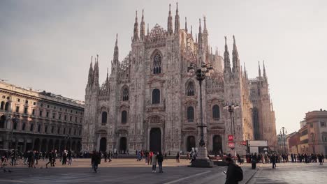 Vista-Frontal-De-La-Catedral-Del-Duomo-Milano-En-Milán-Con-Gente-Caminando-En-La-Plaza-Abierta,-Movimiento-De-Cámara,-Vista-Del-Centro-De-La-Ciudad-Italiana-Con-Turistas