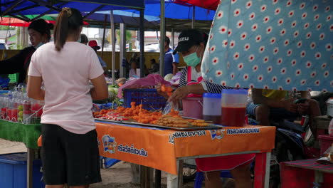 Asiatische-Frau-Kauft-Straßenessen-Am-Imbissstand-Auf-Dem-Lokalen-Markt-In-Thailand