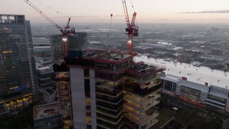 Luftaufnahme-Um-Eine-Wolkenkratzer-Baustelle,-Morgendämmerung-In-Houston,-USA---Kreisend,-Drohnenaufnahme