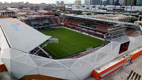 Aerial-view-flying-closely-around-the-PNC-stadium,-cloudy-day-in-Houston,-USA