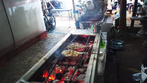 Pescado-A-La-Parrilla,-Mercado-De-Comida-Tradicional-Indonesia,-Playa-En-Sanur,-Bali,-Fuego-De-Las-Brasas-En-La-Carne-Caliente-Entre-Tenazas,-Pasar-Sindhu