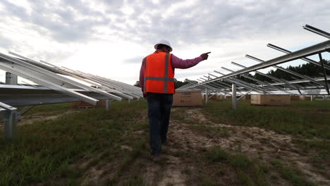 Solar-Panel-field-being-constructed,-with-construction-workers,-walking-and-follow-me-shot