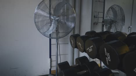 Heben-Von-Hanteln-Auf-Einem-Hantelständer-In-Der-Nähe-Eines-Fitnessraumventilators-In-4K