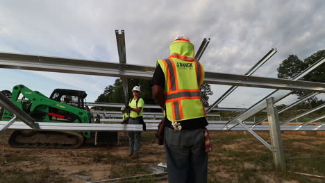 Campo-De-Paneles-Solares-En-Construcción,-Con-Trabajadores-De-La-Construcción