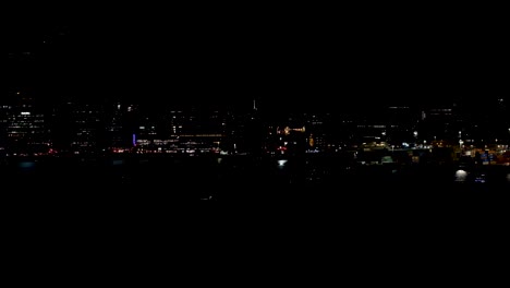 Dark-cityscape-of-flickering-and-flashing-night-lights-of-urban,-inner-city-capital-Wellington,-New-Zealand-Aotearoa