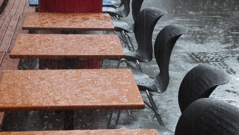 Fuertes-Lluvias-En-La-Terraza-De-Un-Café,-Gotas-De-Lluvia-En-La-Mesa