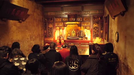 Toma-En-Cámara-Lenta-De-Personas-Asiáticas-Rezando-En-El-Interior-Del-Templo-Baoan-De-Dalongdong-En-Taipei,-Taiwán