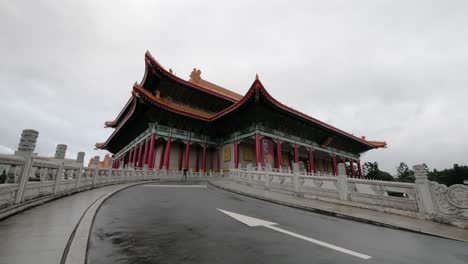 Static-shot-of-young-tourist-running-to-Performing-Arts-Library-of-National-Theater-and-Concert-Hall-in-Taipei,-Taiwan