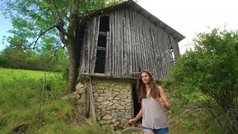 Eine-Frau-Verlässt-Eine-Alte,-Verlassene-Steinhütte-Mitten-Im-Wald-Und-Setzt-Ihren-Weg-Fort