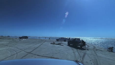 Fahren-Sie-An-Einem-Neuseeländischen-Strand-Entlang-Und-Beobachten-Sie-Menschen-Beim-Angeln-An-Einem-Wunderschönen,-Sonnigen-Tag-Mit-Blauem-Himmel