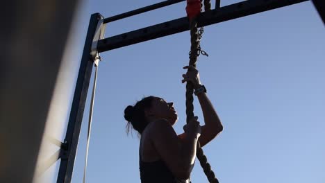 Atleta-Femenina-Que-Llega-A-La-Cima-De-Una-Escalada-De-Cuerda-En-Una-Competencia-De-Cross-Fit