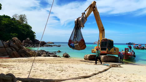A-shot-of-an-excavator-working-by-the-beach-with-men-and-boat