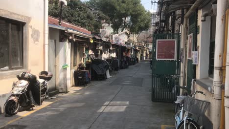 hand-held-shot-of-an-urban-genuine-musty-backyard-area-in-French-Concession,-Shanghai-on-a-cold-sunny-blue-sky-day