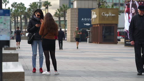 Women-checking-their-phones-while-people-running-in-the-background