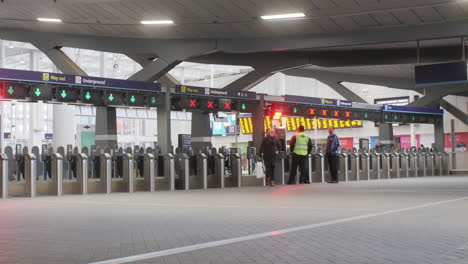 ZOOM-OUT-on-mother-and-child-entering-a-modern-British-railway-station