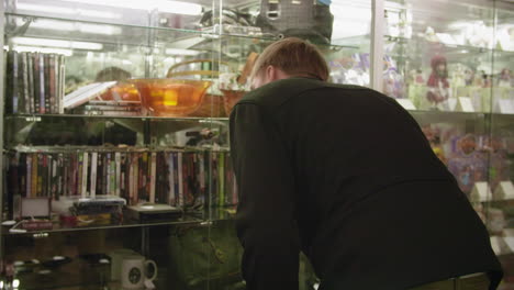 Man-Looking-in-Display-Case-at-Flea-Market-SLOW-MOTION