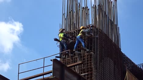 Bauarbeiter,-Die-In-Der-Höhe-Arbeiten-Und-Auf-Der-Baustelle-Stahlbewehrungsstäbe-Herstellen