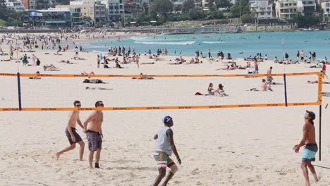 A-group-of-four-friends-playing-a-game-of-beach-volleyball-on-a-spring-day-at-Bondi-Beach-Sydney-Australia