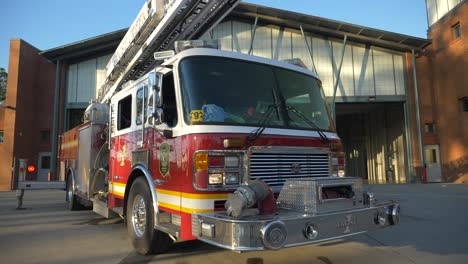 Fire-engine-sits-shiny-outside-of-a-fire-station-in-the-early-morning-sunlight