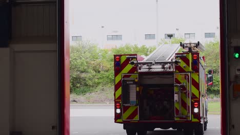 Man-Sieht,-Wie-Ein-Rotes-Feuerwehrauto-Nach-Abschluss-Der-Kontrollen-Durch-Die-Besatzung-Rückwärts-In-Die-Feuerwache-Einfährt