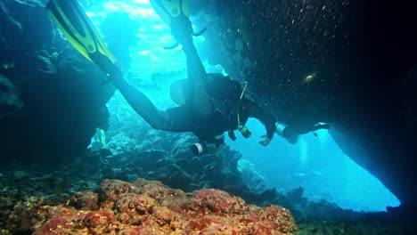 Taucher-Schwimmt-Zwischen-Den-Felsen