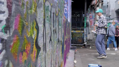 Junger-Graffiti-Künstler-Malt-Mit-Roter-Sprühfarbe-In-Hoiser-Lane,-Melbourne,-Juli-2019-Graffiti-An-Der-Wand,-Straßenspray-Kunstwerk-In-Hosier-Lane,-Melbourne,-CBD