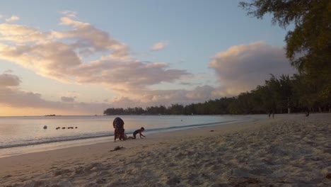 Mujer-Musulmana-Jugando-Con-Sus-Hijos-En-Una-Playa-En-Una-Hermosa-Puesta-De-Sol