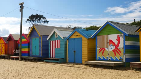 Tourists-walking-and-taking-photo-at-Brighton-Bathing-Boxes,-Melbourne,-Australia