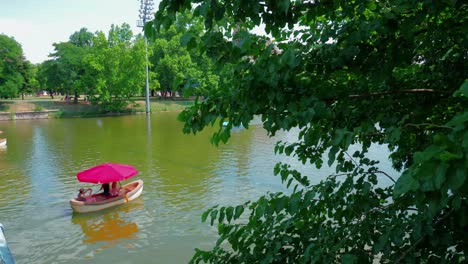 Parque-De-La-Ciudad-Del-Lago-Városligeti,-Botes-De-Remo-Desde-El-Otro-Lado-Del-Puente,-Continuar-Tiro-1